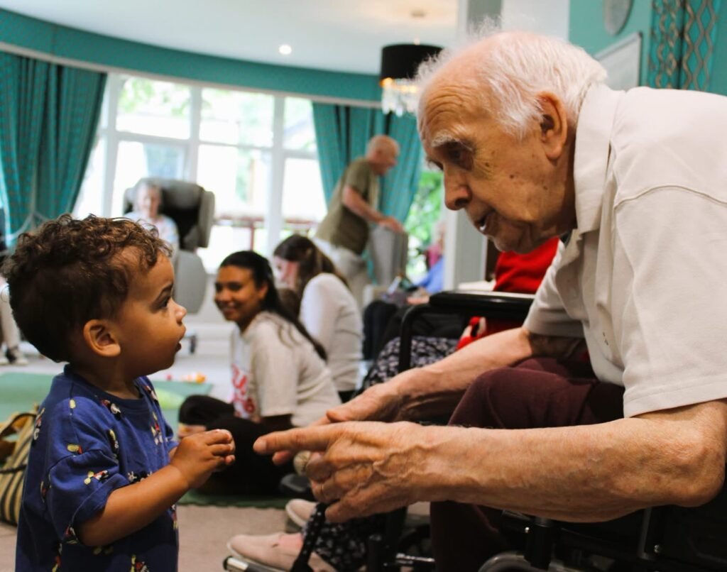 Toddler and care home resident sharing a moment at a Rock Out Baby session